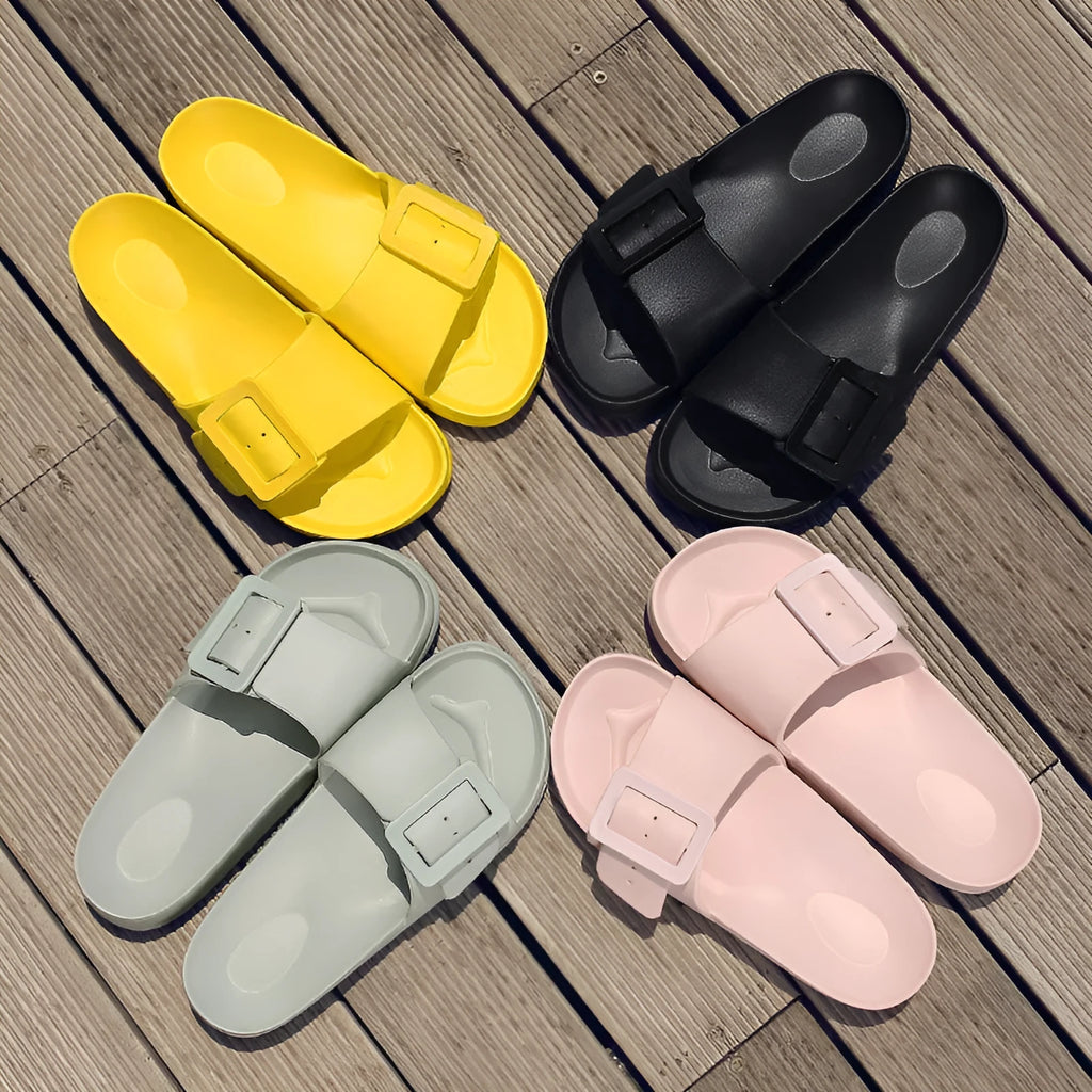 A pair of women's grey blue buckle slipper sandals with an adjustable strap on a soft EVA sole.