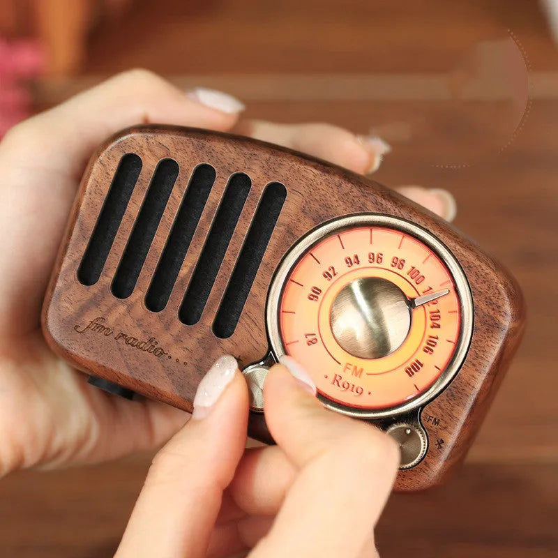 Retro wooden wireless mini speaker in cherry wood finish showing compact size.