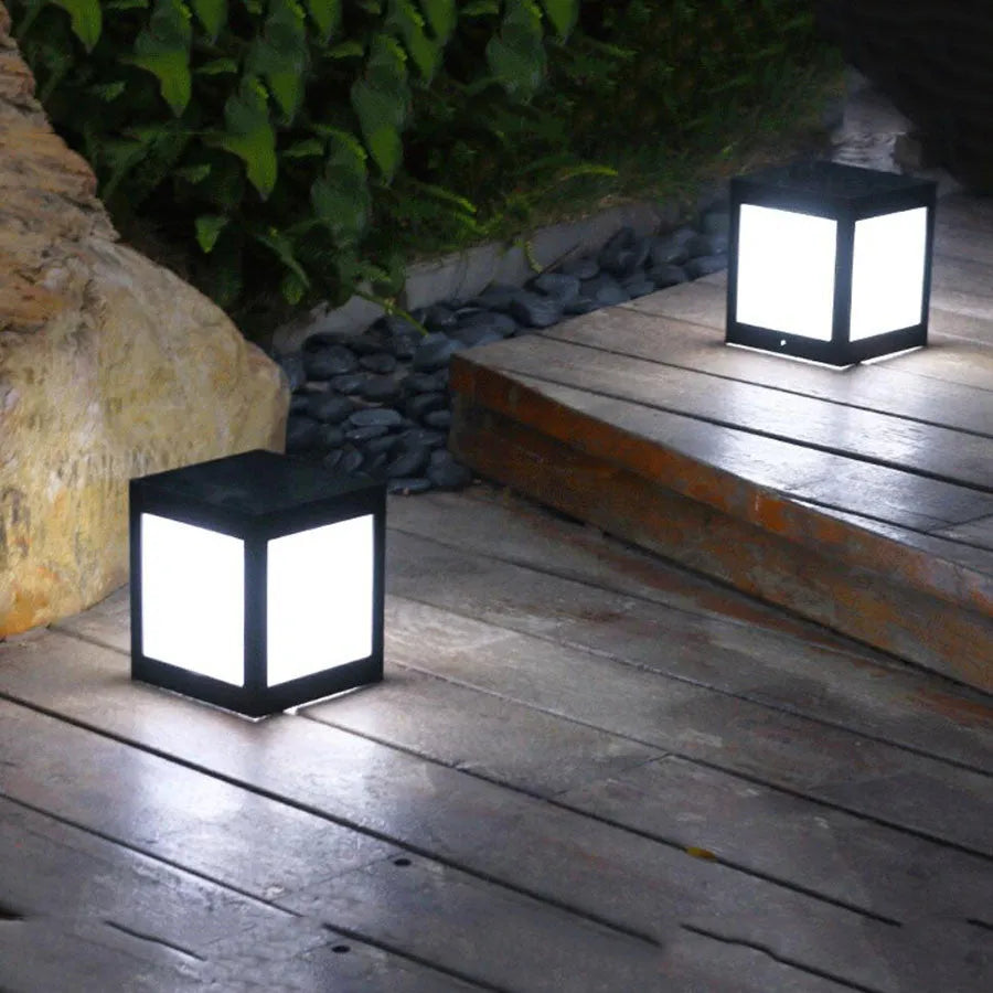 Set of four different styles of solar-powered LED garden lights for outdoor use.