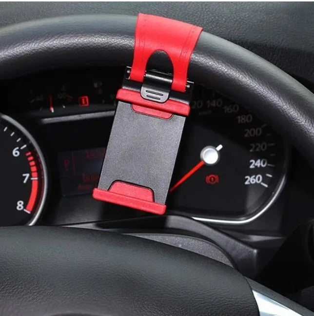Black universal steering wheel phone clip holder with silicone pad mounted on a car steering wheel.