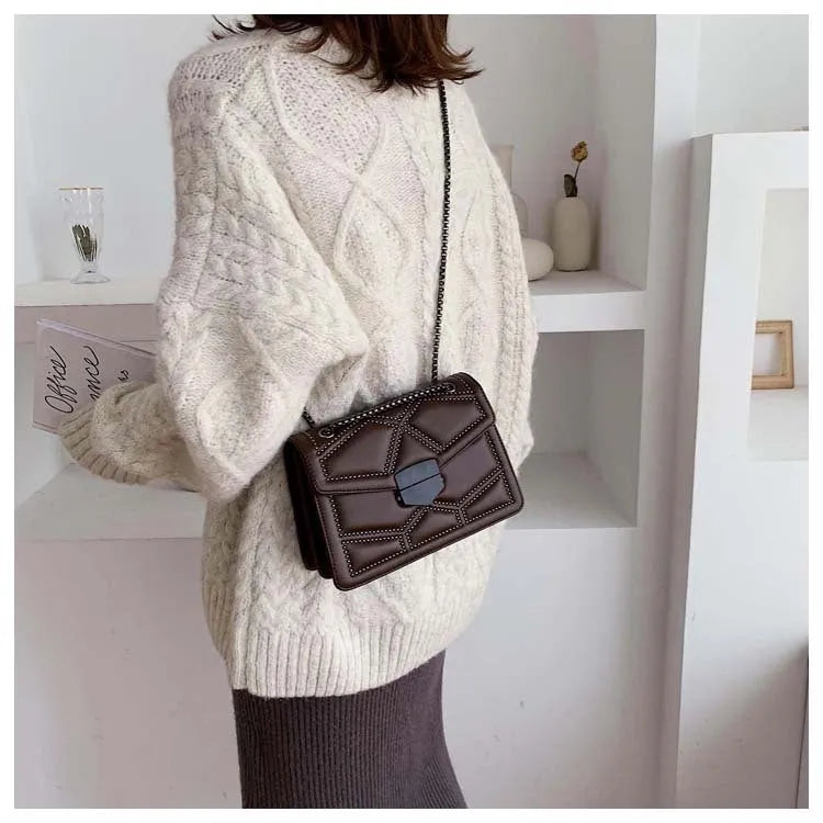 Small square shoulder bag with studs, chain handle, and zipper closure in wine red colour