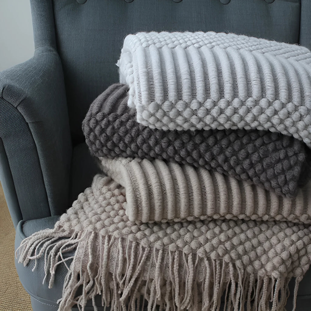 Small grey polyester nap blanket folded, showing its 127x170cm size on a sofa.