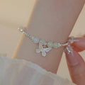 Women's copper butterfly jewellery set with electroplated silver finish, showing bracelet and necklace