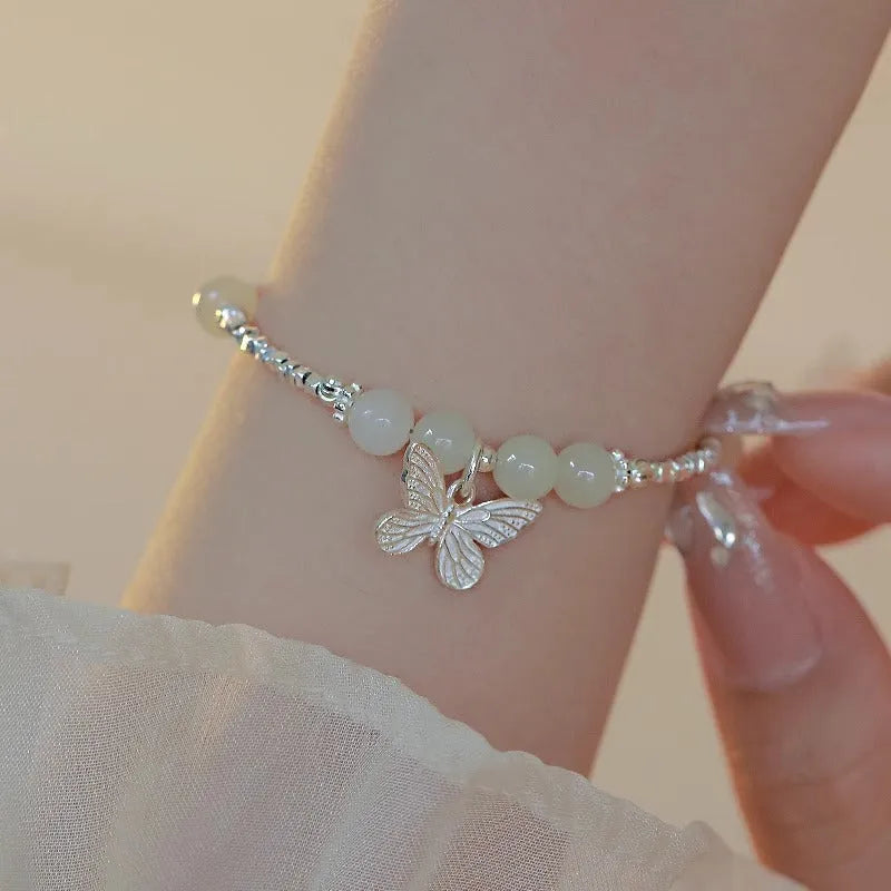 Women's copper butterfly jewellery set with electroplated silver finish, showing bracelet and necklace