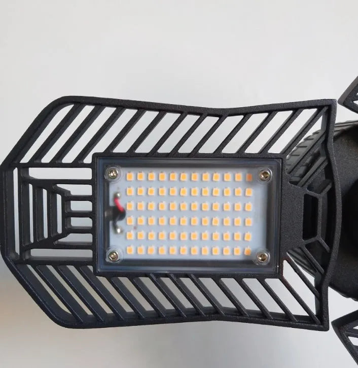 Industrial foldable waterproof LED garage lamp with die-cast aluminium housing shown in a workshop setting.