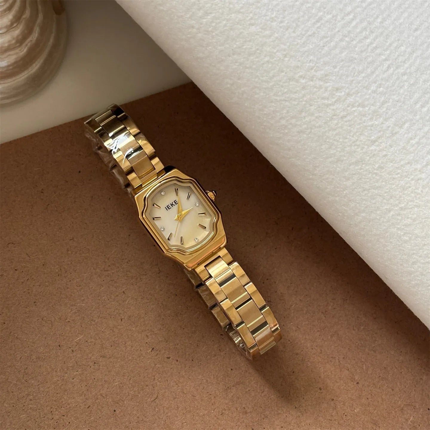 Women's small square watch with gold strap and green dial, 10mm thin, on wrist