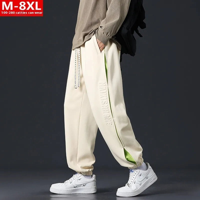 Men's loose fit cotton trousers with stitching detail and a banded ankle cuff.