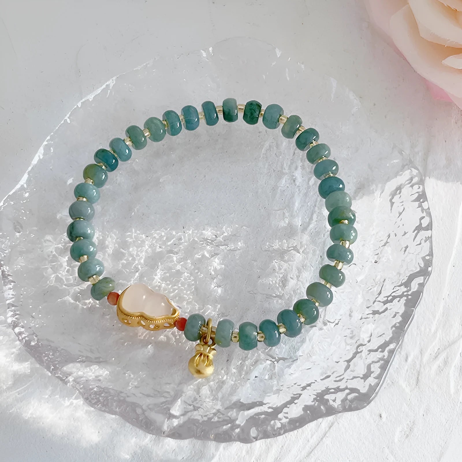 Women's simple jade bracelet with blue gourd charm and silver peace buckle on a beaded strand.