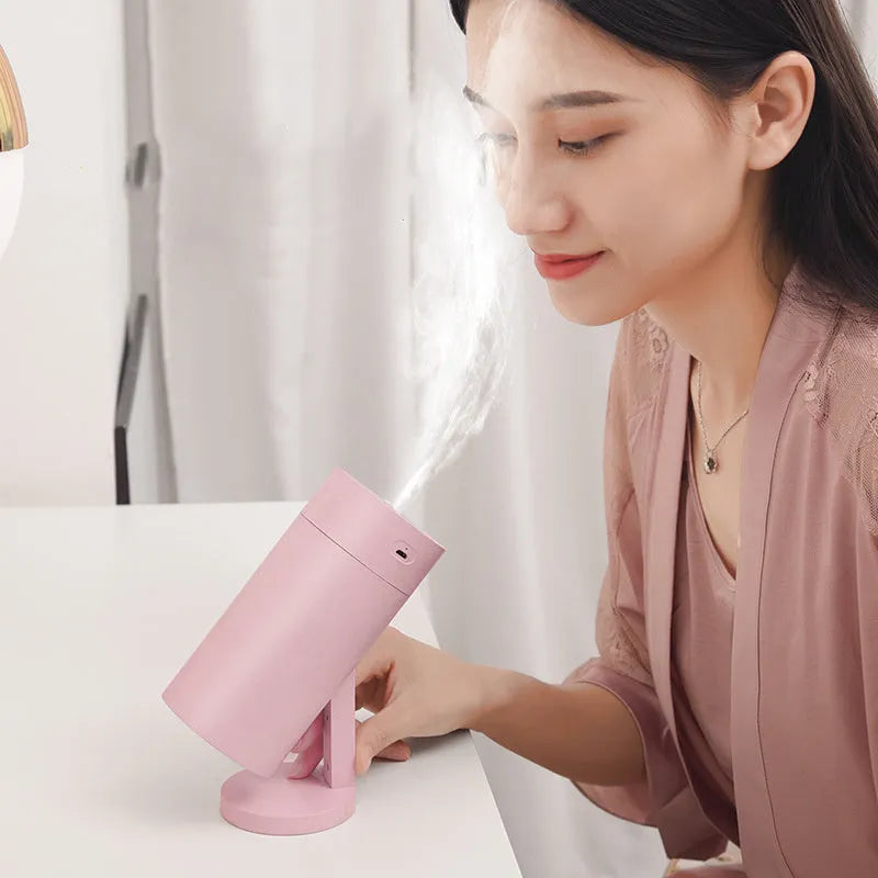 Blue folding bracket USB desktop humidifier with water tank on a wooden desk