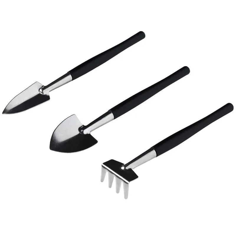 Black plastic and metal mini garden tool set for succulents, with tools laid out on a 75cm square cushion.