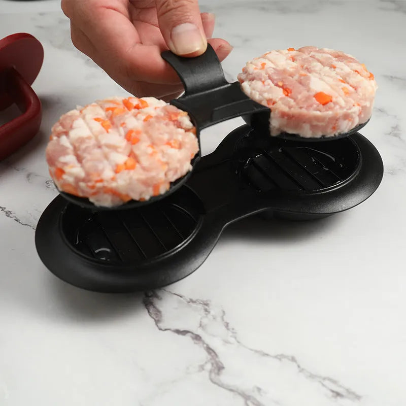 Black food-grade ABS burger press kitchen gadget on a kitchen counter.