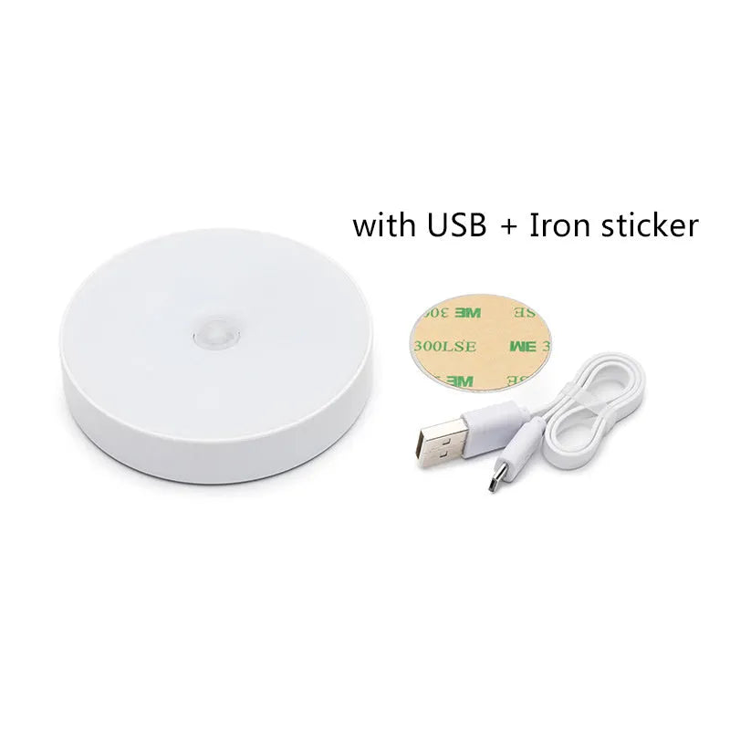 Compact white motion-activated USB rechargeable LED night light with adhesive tape.