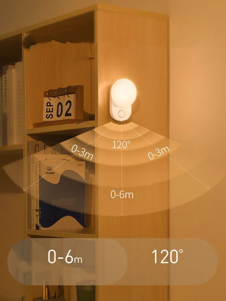 White Baseus rechargeable sensor night light with LED glow, shown on a bedside table.