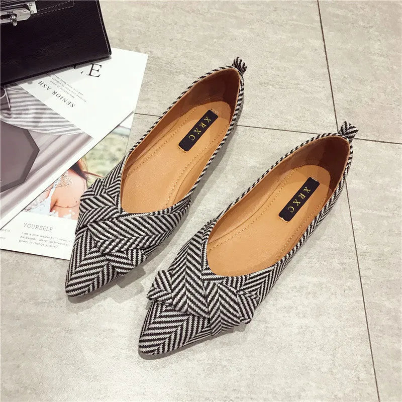 Red women's pointed toe flat shoes with a cotton upper and low flat heel on a white background.