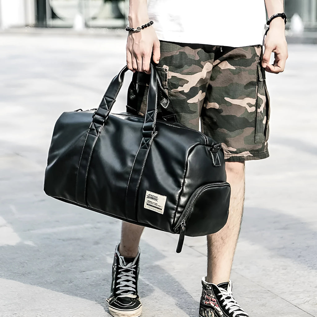 Large black waterproof PU leather sports bag showing internal organiser with laptop and camera pockets.