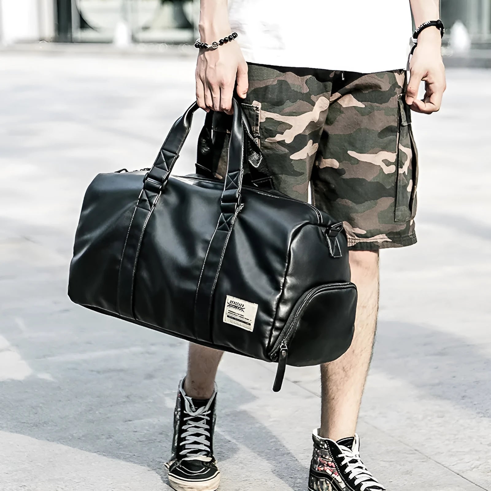 Large black waterproof PU leather sports bag showing internal organiser with laptop and camera pockets.