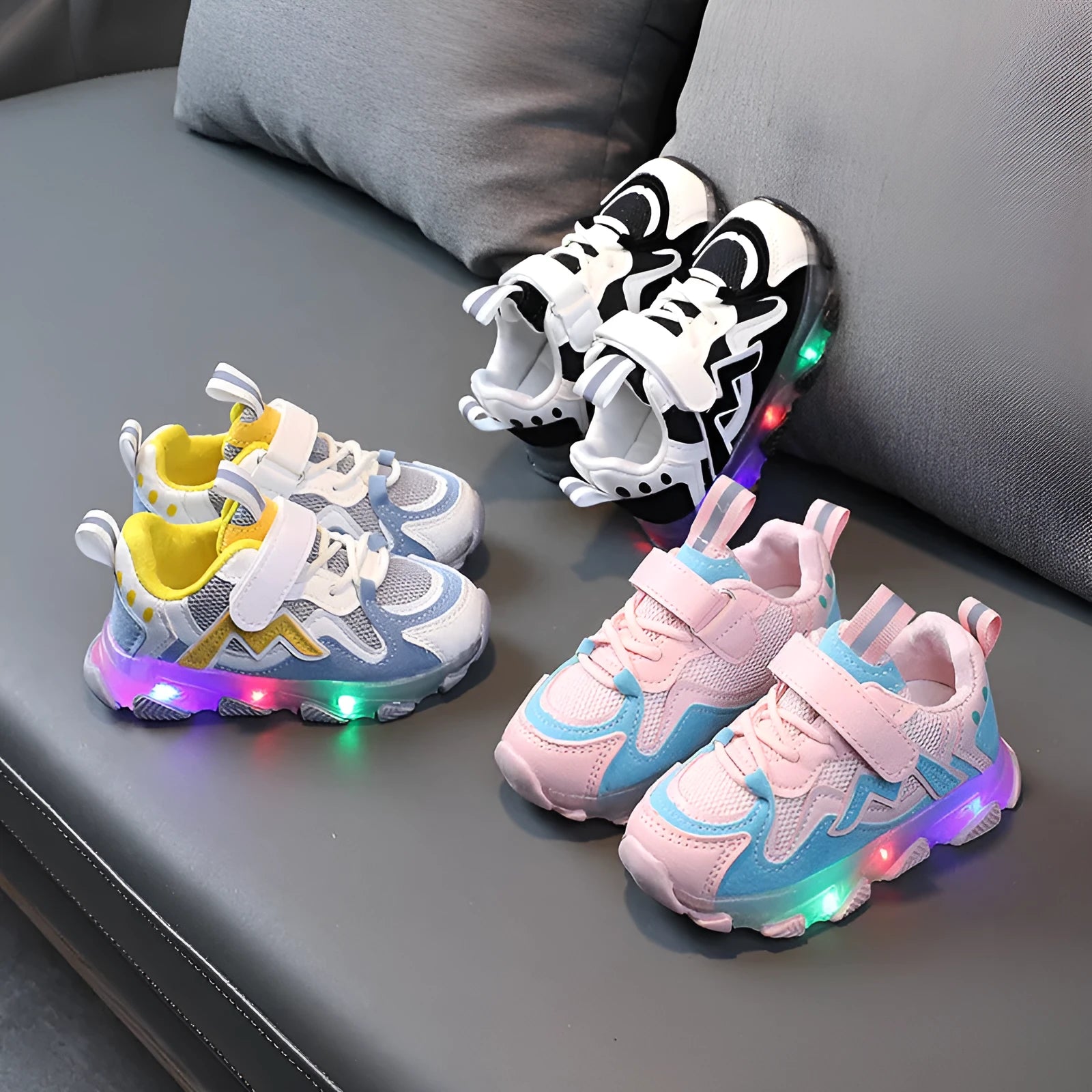 Black, pink, and grey children's Velcro sneakers with mesh panels and a rubber sole.