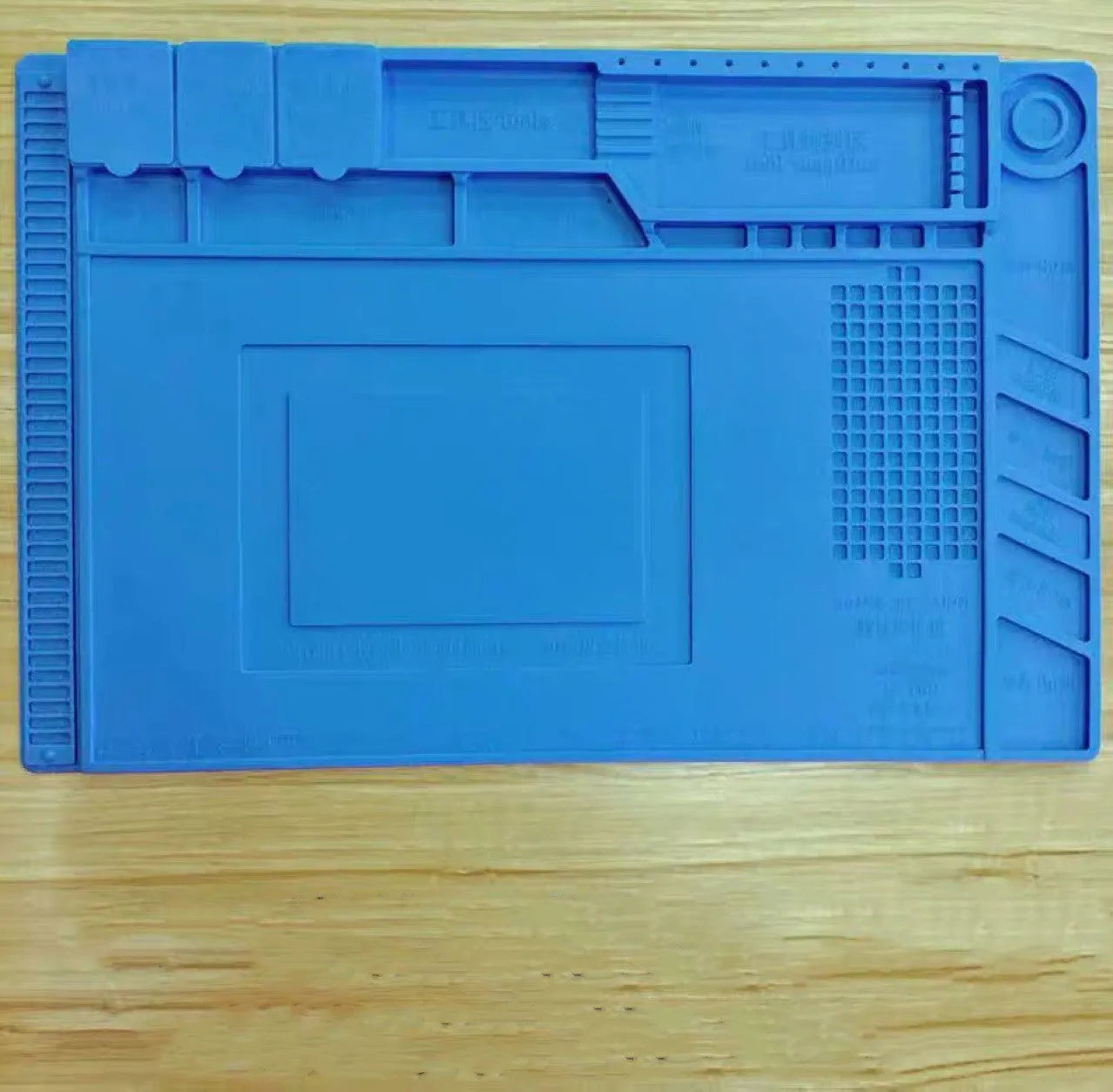 Blue mobile phone computer repair magnetic heat insulation work mat on a desk