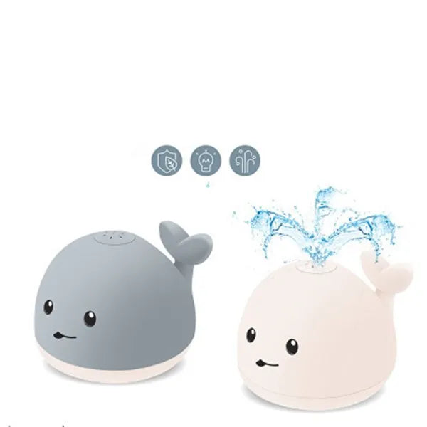 Grey and white whale bath toy spraying water with LED lights on water surface