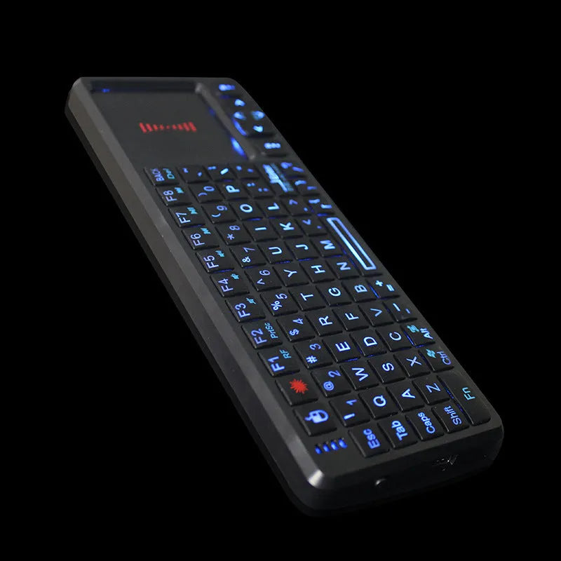 Black wireless laser teaching mini keyboard with a touch screen and backlit keys on a desk.