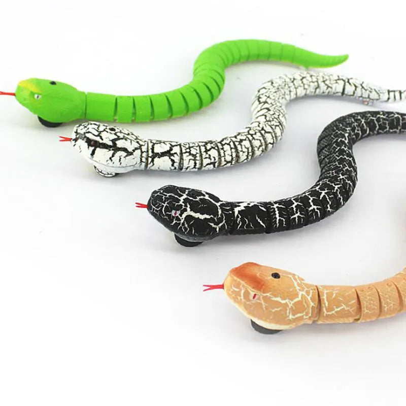 Remote control black cobra snake toy with USB charging cable and batteries on floor