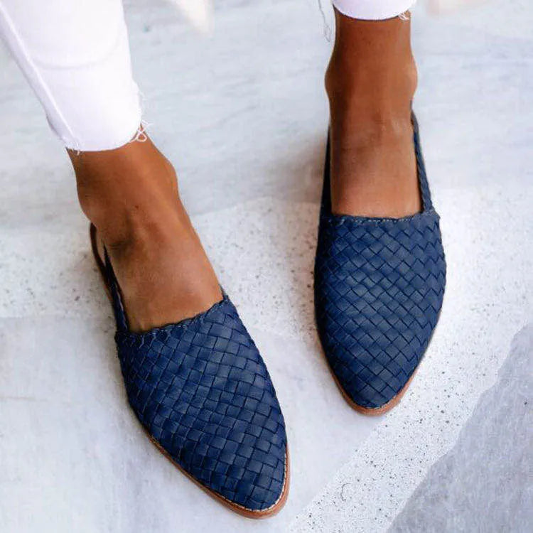 A pair of pointed toe, baotou flat sandals with a central buckle fastening, shown in a selection of colours.