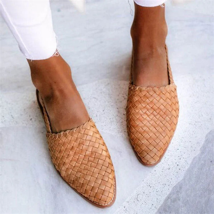 A pair of pointed toe, baotou flat sandals with a central buckle fastening, shown in a selection of colours.