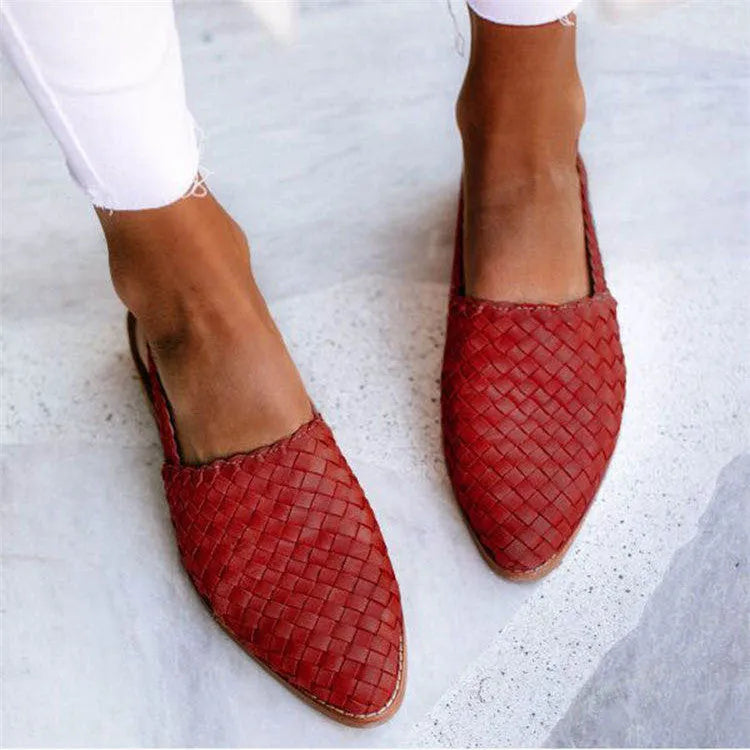 A pair of pointed toe, baotou flat sandals with a central buckle fastening, shown in a selection of colours.