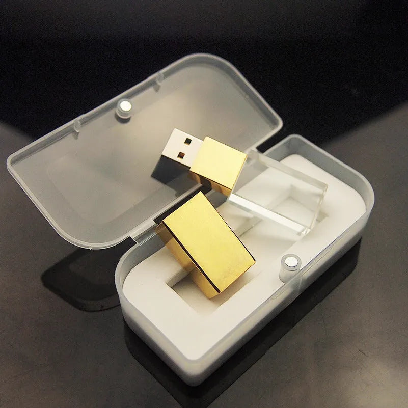 Transparent glass USB flash drive with stainless steel frame in gold colour showing USB connector
