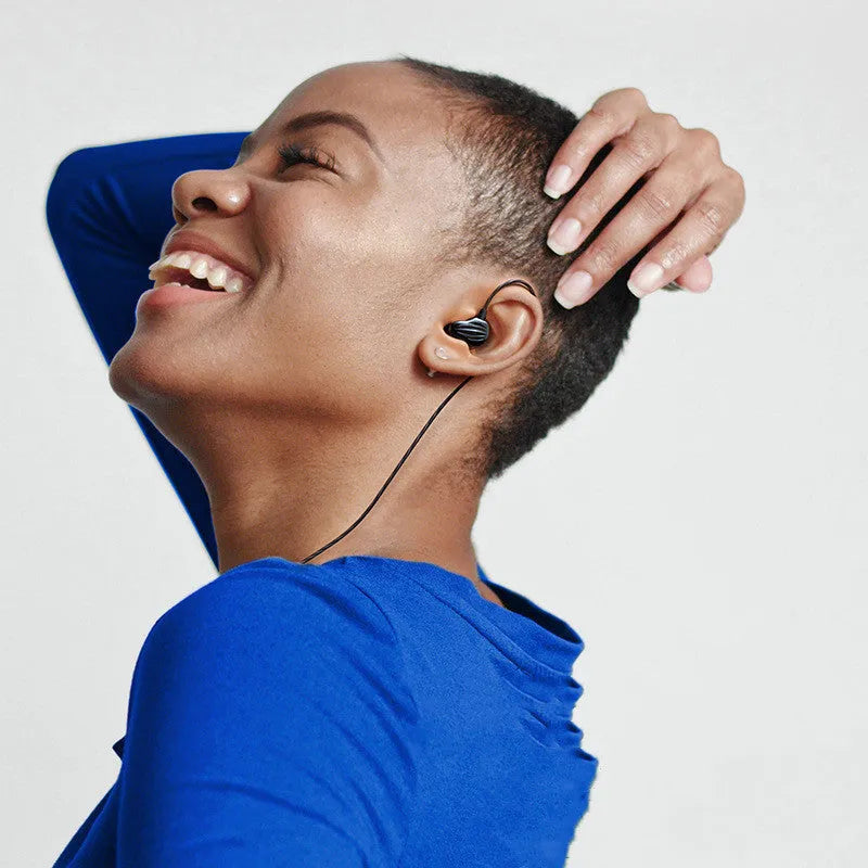 White in-ear sports headphones with black around-ear hook and 3.5mm plug on a red background.