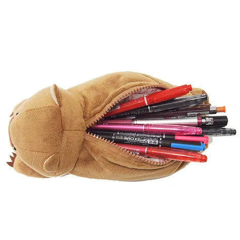 Brown plush wombat cartoon animal pencil case with zip, shown next to pens and pencils.