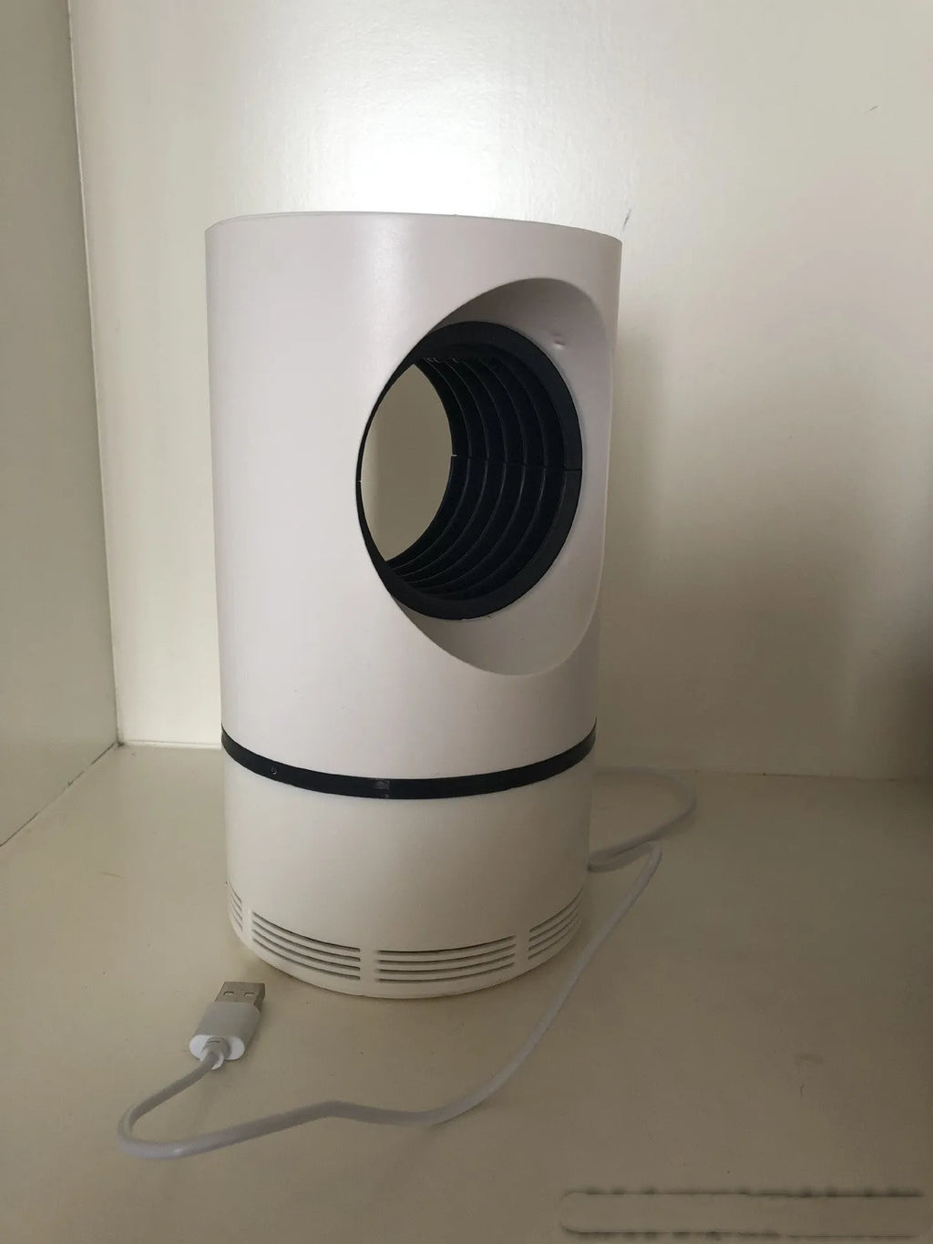 Large white photocatalyst mosquito killer lamp with USB cable on a flat surface