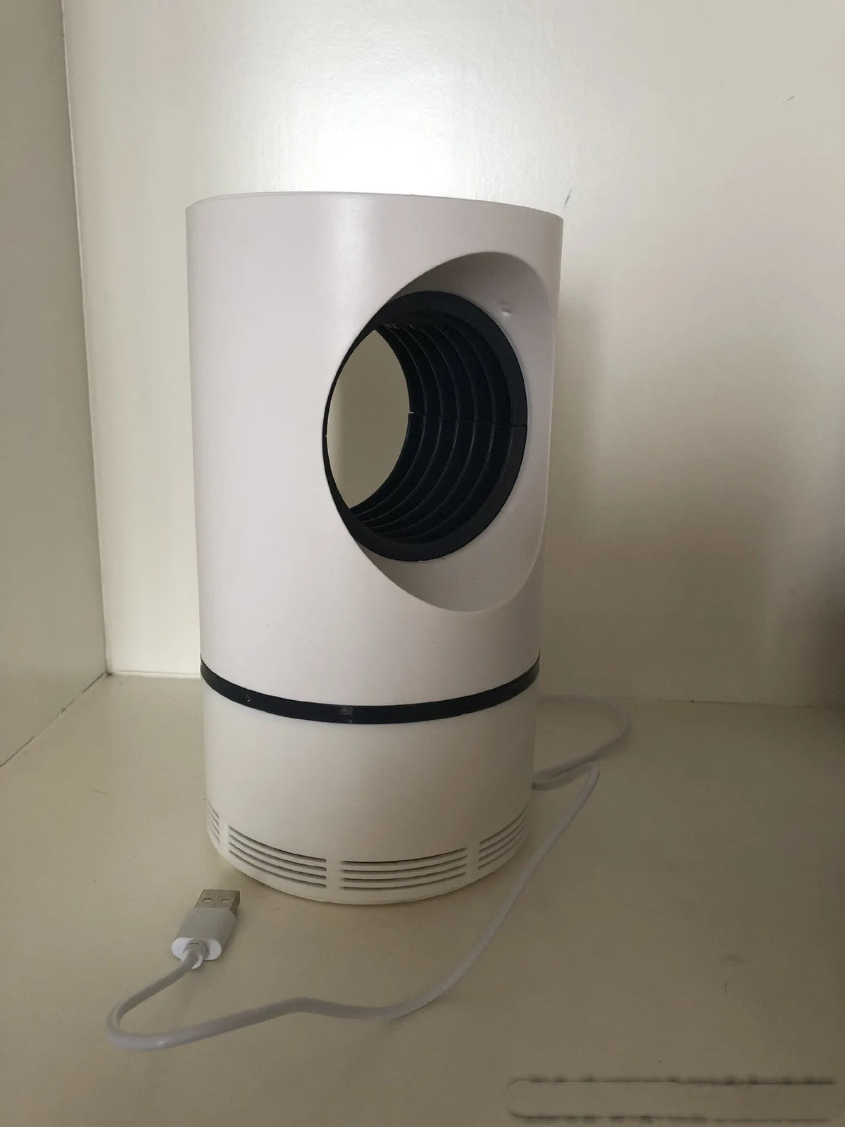 Large white photocatalyst mosquito killer lamp with USB cable on a flat surface