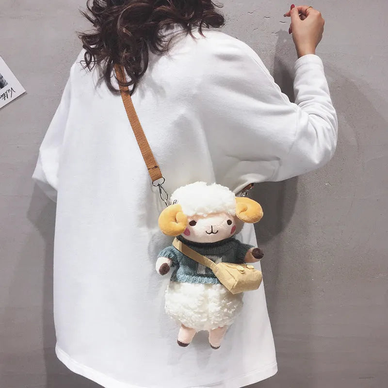 Soft blue plush crossbody bag with a lamb pattern, showing zip opening and shoulder strap.