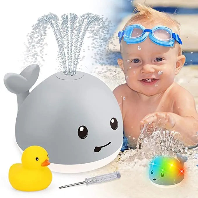 Grey and white whale bath toy spraying water with LED lights on water surface