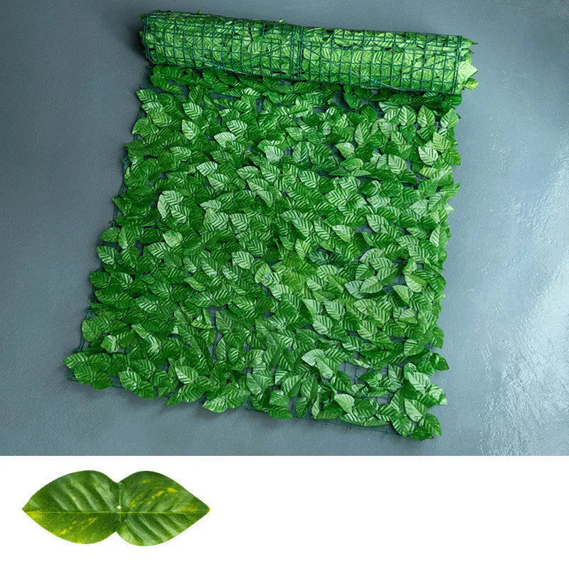 Green artificial plastic fence net with realistic colour-printed leaves, shown in a garden setting.