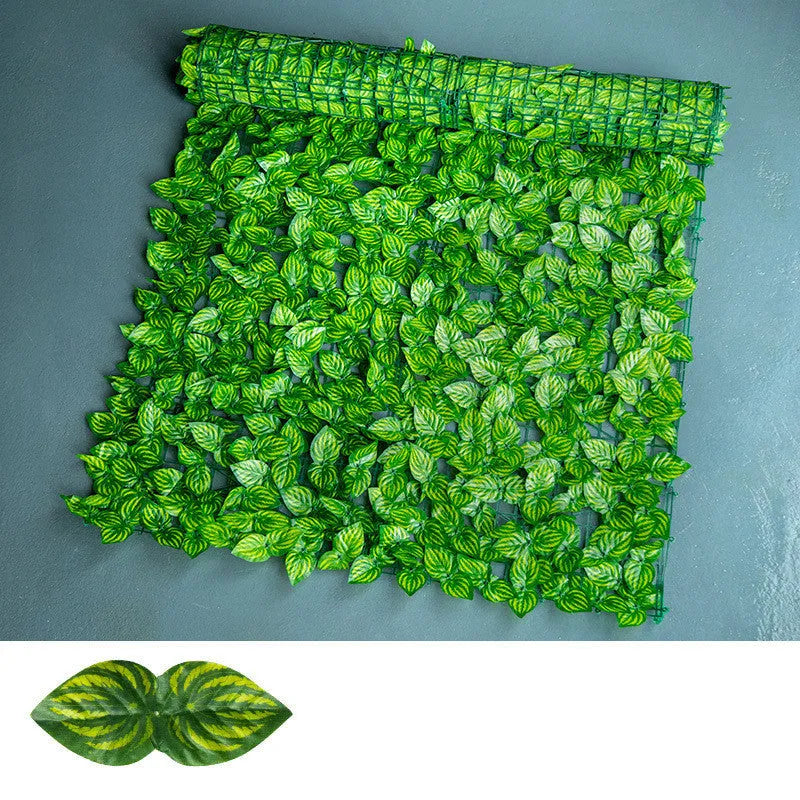 Green artificial plastic fence net with realistic colour-printed leaves, shown in a garden setting.
