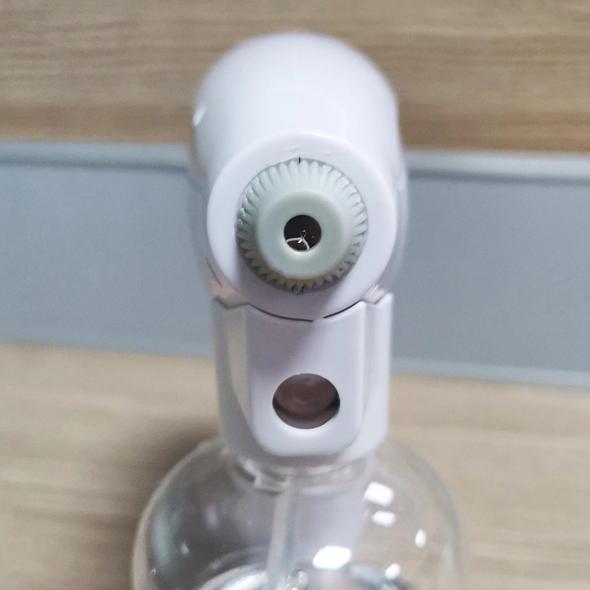 White handheld wireless electric spray disinfection gun with USB-C port and bottle attached