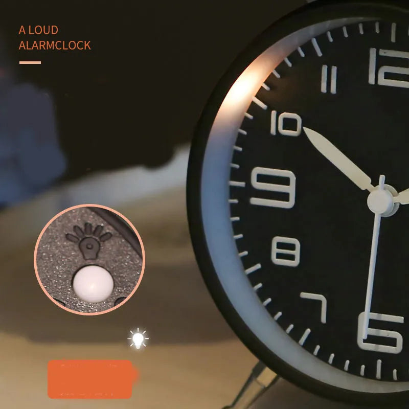 Large black metal alarm clock with luminous hands and 4-inch glass dial on a bedside table