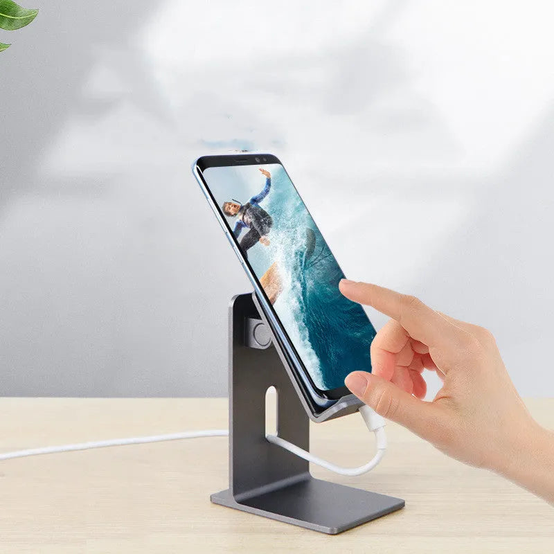 Dark space grey alloy mobile phone holder with lazy bracket, holding a smartphone on a wooden desk.