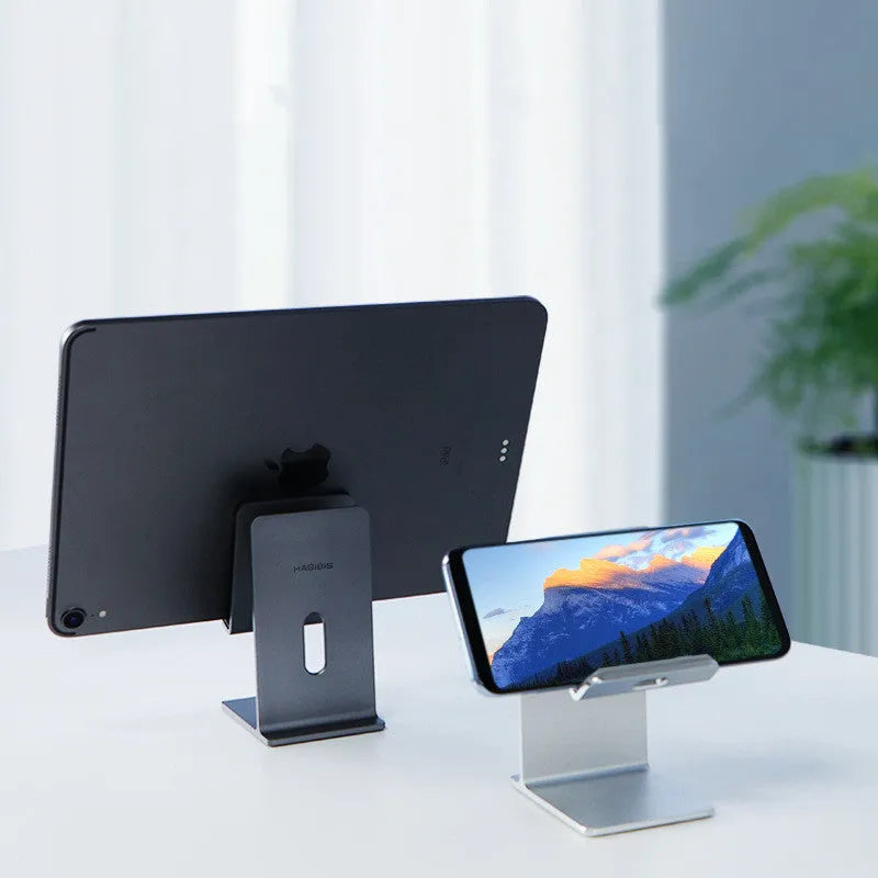 Dark space grey alloy mobile phone holder with lazy bracket, holding a smartphone on a wooden desk.