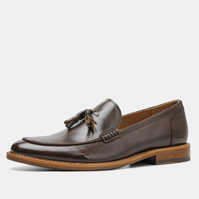 Brown PU leather men's loafers with tassel detail on a round toe, low-cut profile, grey background