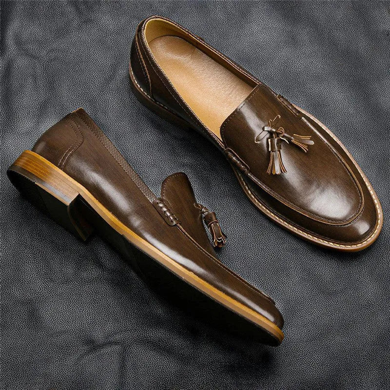 Brown PU leather men's loafers with tassel detail on a round toe, low-cut profile, grey background