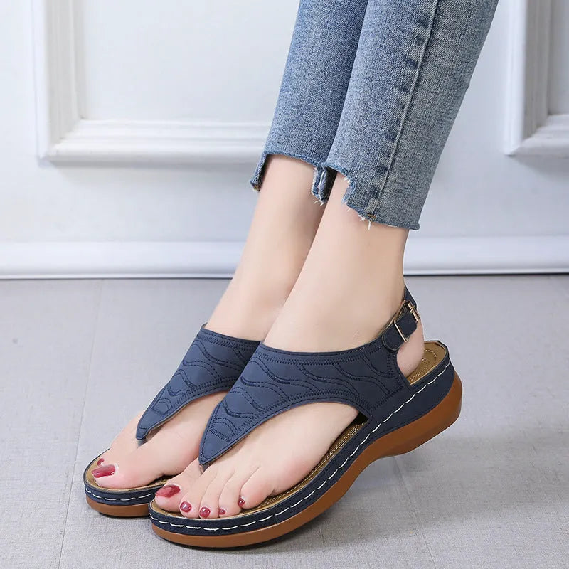 Women's casual wedge heel flip flop sandal in black with adjustable buckle strap.