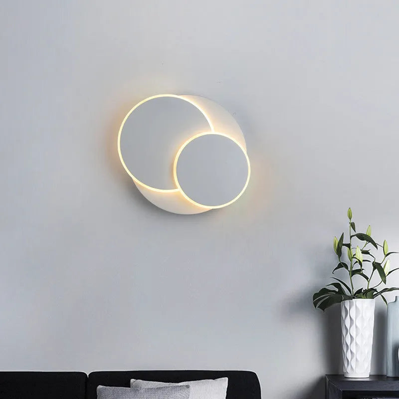 Modern round white acrylic wall lamp mounted on a wall with push button switch.