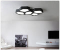 Geometric shaped black iron LED pendant light with remote control for dimming and colour temperature adjustment.