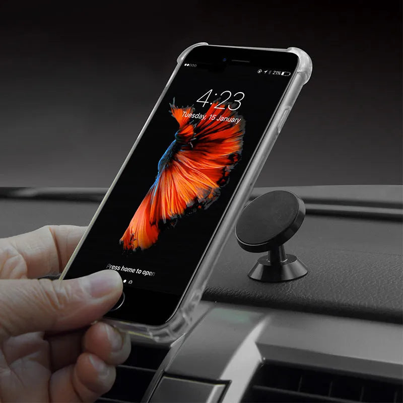 Black magnetic car phone holder mounted on dashboard with smartphone attached