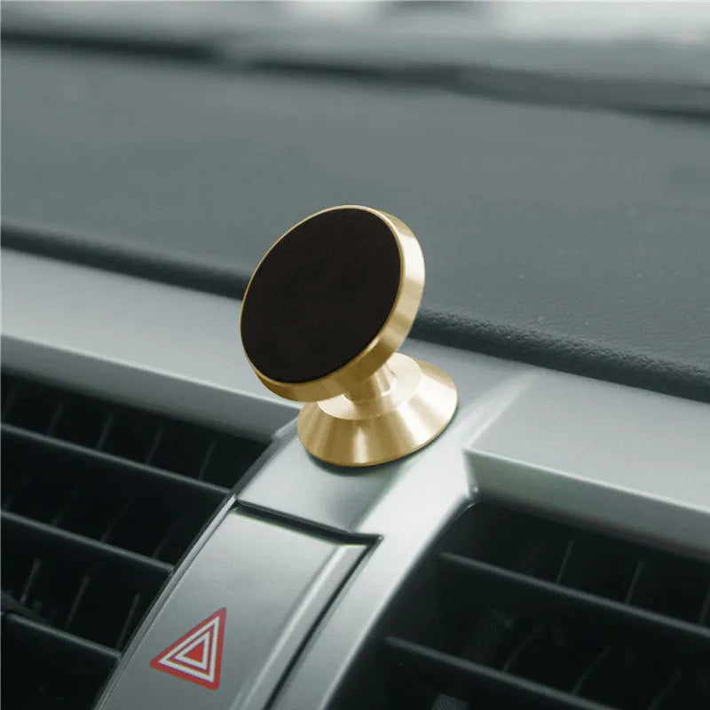Black magnetic car phone holder mounted on dashboard with smartphone attached