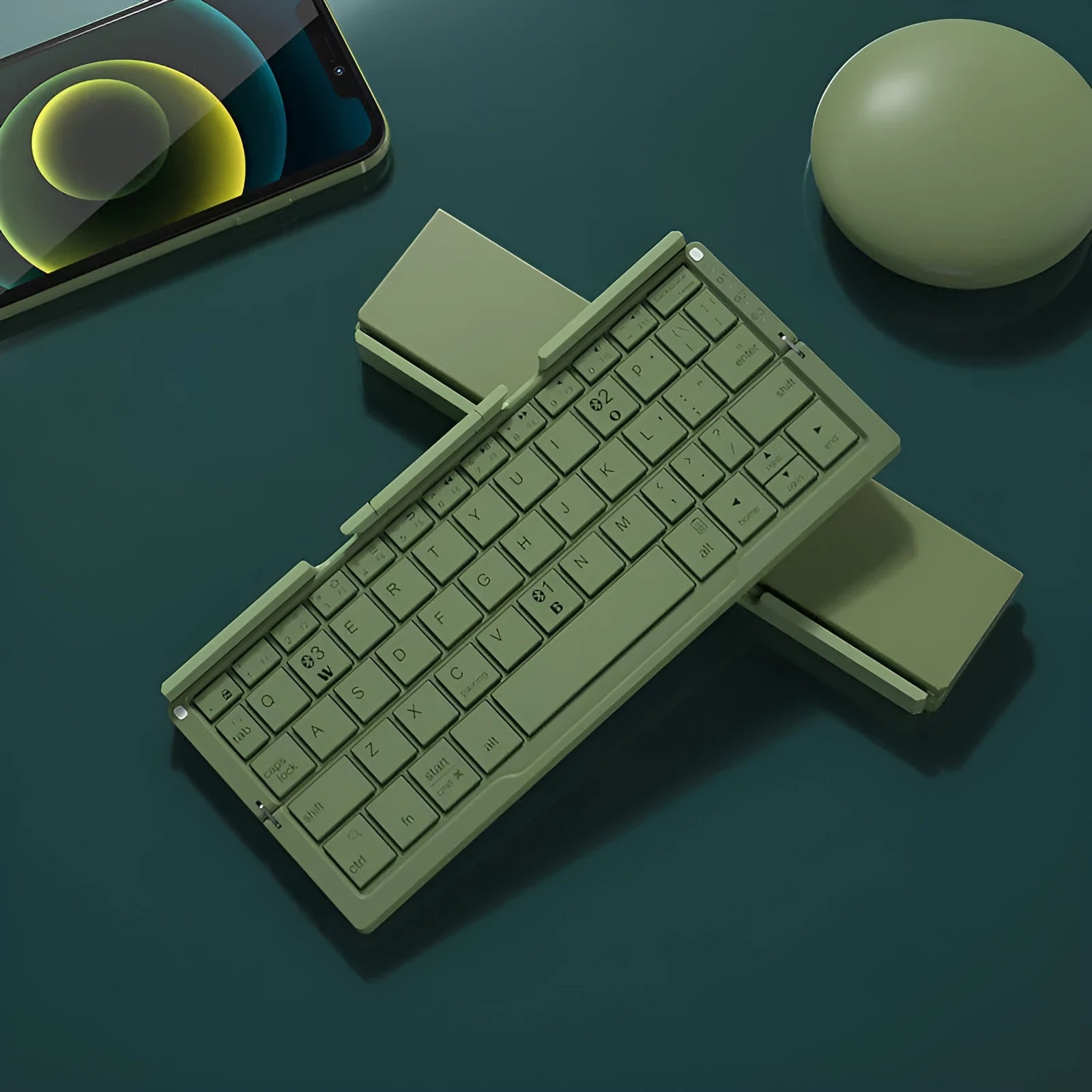 Silver white folding Bluetooth keyboard open with stand holding a smartphone, shown next to its compact folded size.