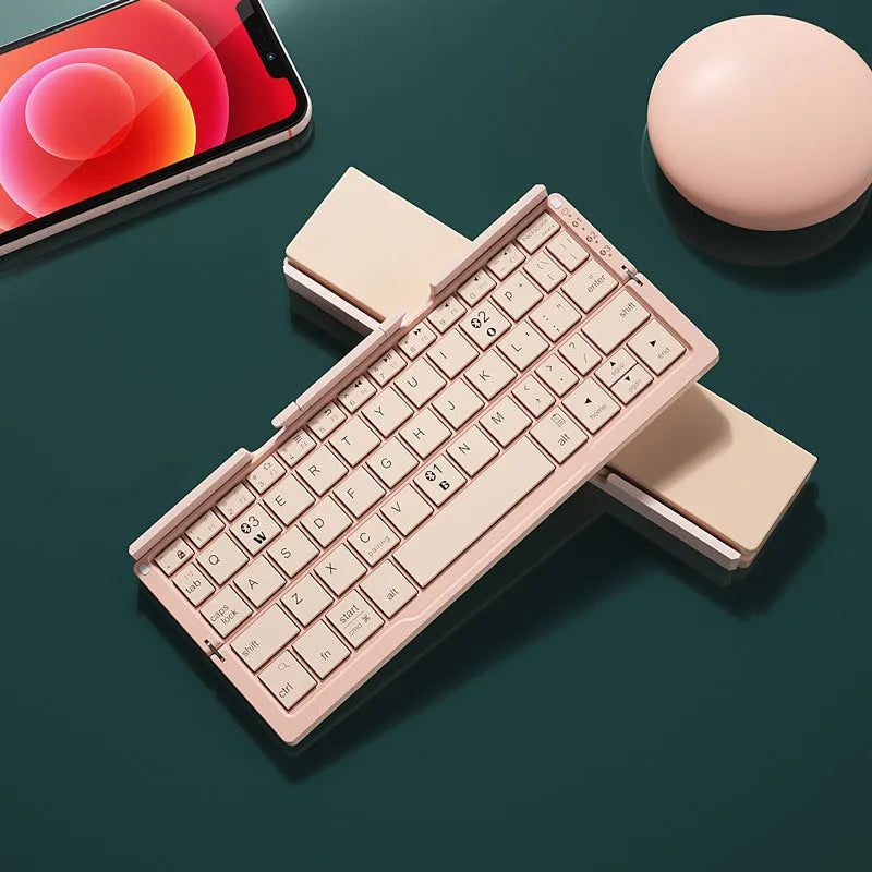 Silver white folding Bluetooth keyboard open with stand holding a smartphone, shown next to its compact folded size.